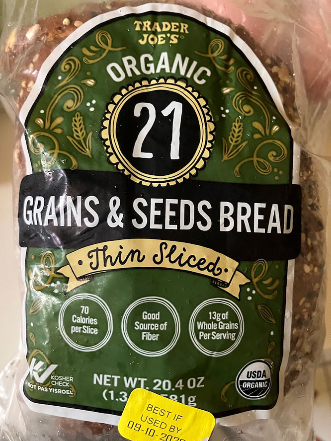 Trader Joe's Organic 21 Grains & Seeds Bread, Thin Sliced, 20.4 oz package, featuring nutritional information including 70 calories per slice, good source of fiber, and 13g of whole grains per serving.